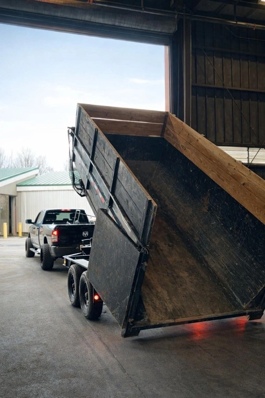 Dump trailer hitched to a pickup inside a transfer facility